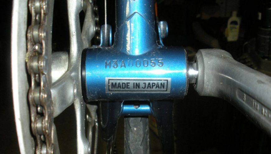 Close-up of a bicycle serial number stamped on the bottom bracket shell (underside near the pedals) — used for identification, theft recovery, and crash reconstruction